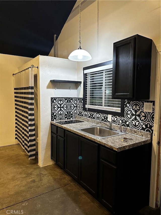 kitchen with lofted ceiling, black electric cooktop, dark cabinetry, open shelves, and a sink