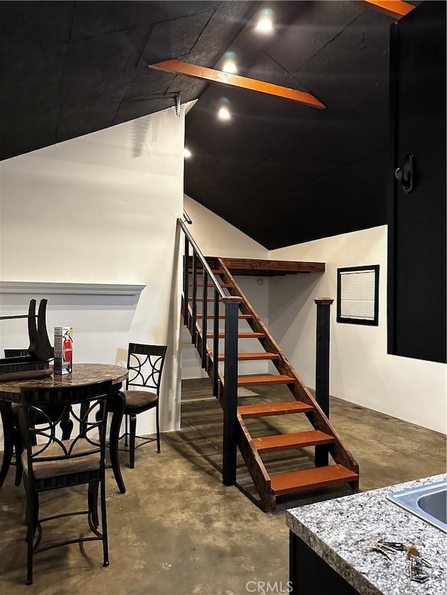 stairs featuring concrete flooring and lofted ceiling