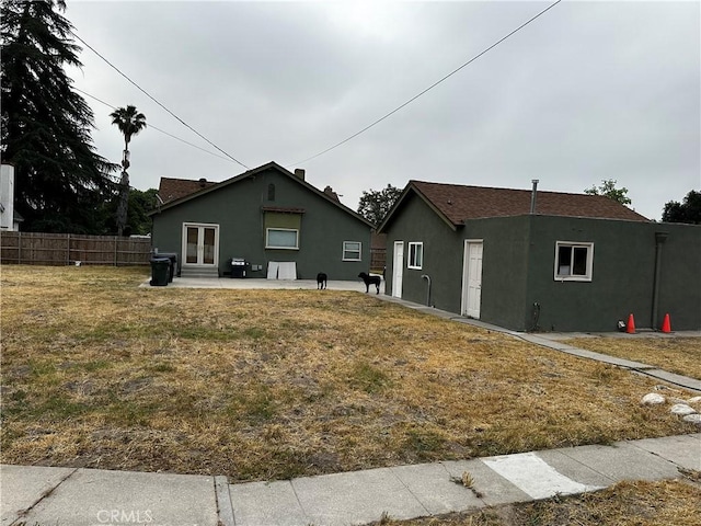 back of house featuring french doors, a patio area, fence, and stucco siding