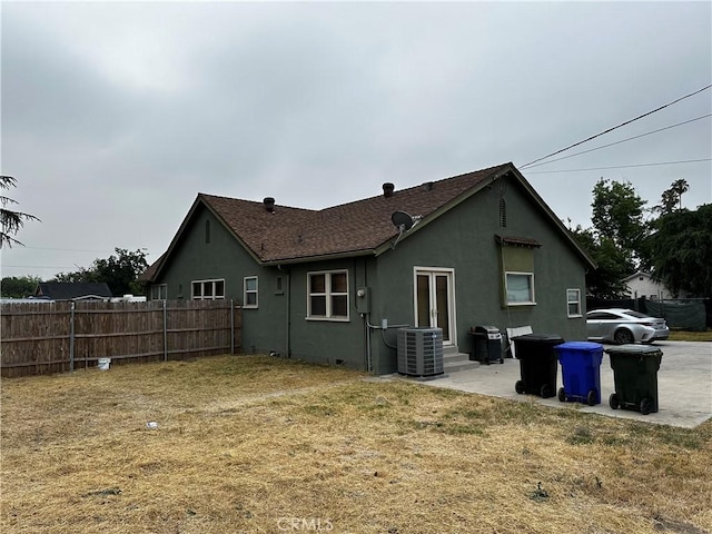 back of house with a yard, cooling unit, fence, and stucco siding