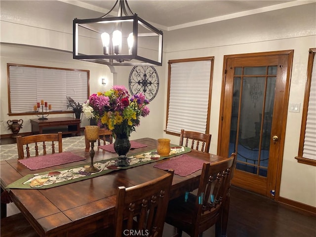 dining area featuring baseboards, a notable chandelier, and wood finished floors