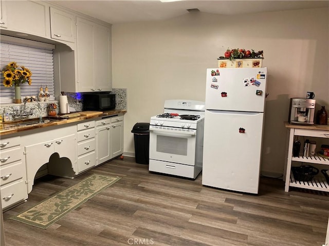 kitchen with white appliances, dark wood-type flooring, a sink, and white cabinets