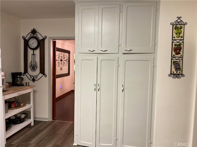 interior space featuring dark wood-type flooring and baseboards