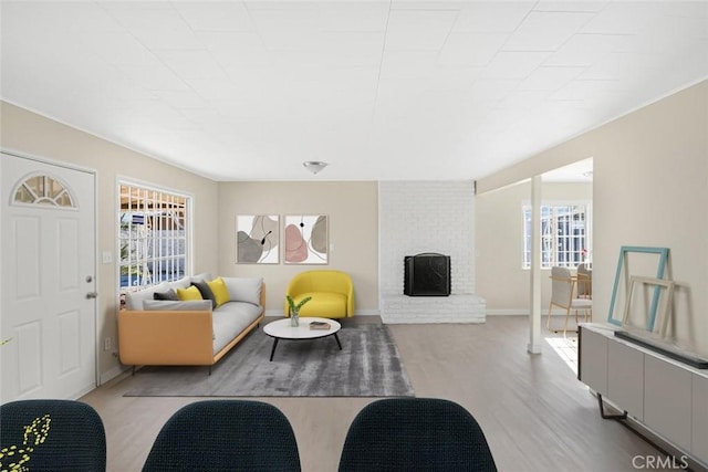 living room with plenty of natural light, a fireplace, and wood finished floors