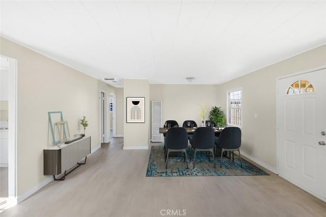 dining space featuring baseboards and light wood finished floors