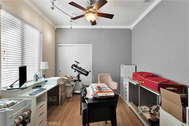 office area with ornamental molding, light wood-style floors, and a ceiling fan