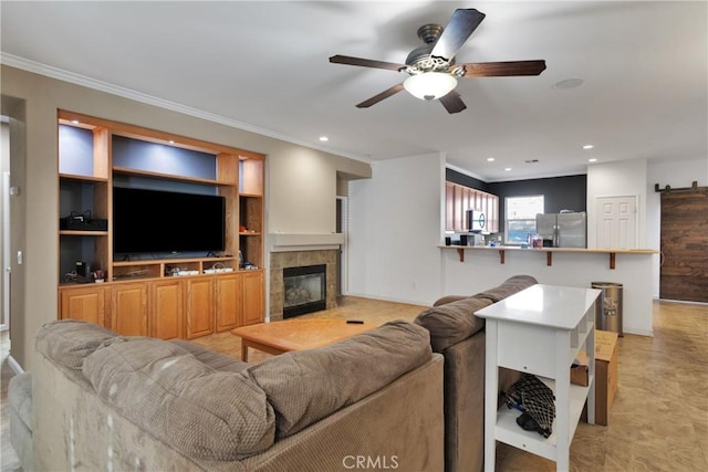 living room with ornamental molding, a tile fireplace, ceiling fan, and recessed lighting