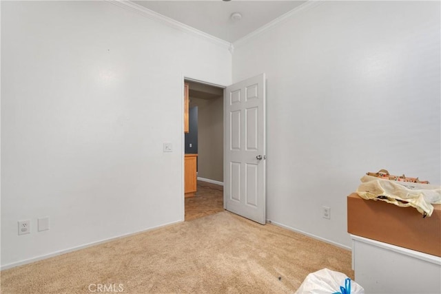 unfurnished bedroom featuring crown molding, baseboards, and light colored carpet