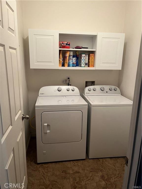 washroom featuring washing machine and dryer and cabinet space