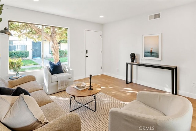 living area featuring baseboards, visible vents, and recessed lighting