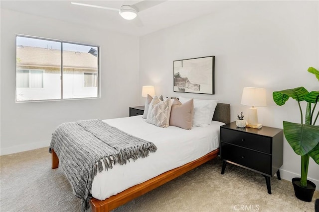 carpeted bedroom with ceiling fan and baseboards