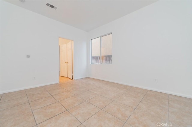 spare room with light tile patterned floors, baseboards, and visible vents