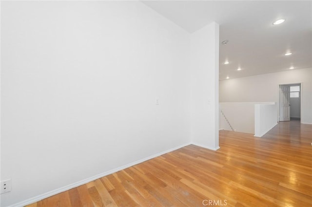 unfurnished room with light wood-style floors, baseboards, and recessed lighting