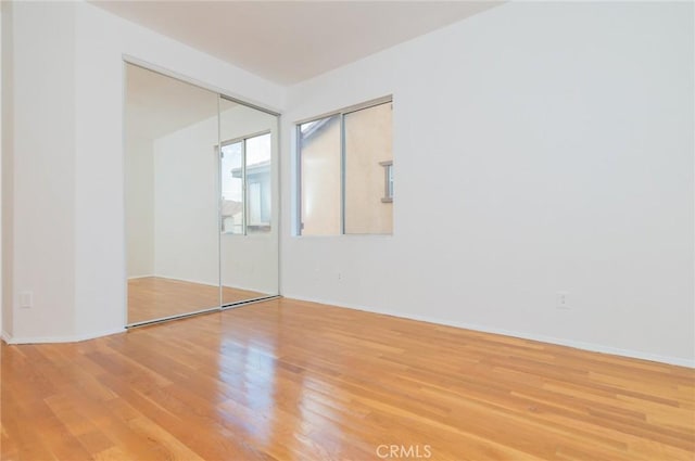 unfurnished bedroom featuring a closet and light wood finished floors