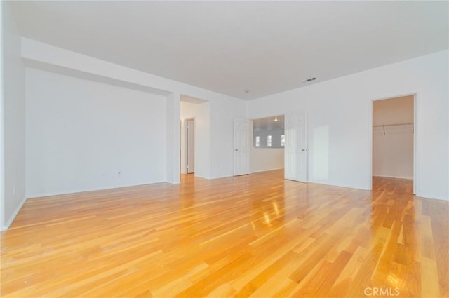 spare room with light wood finished floors and visible vents