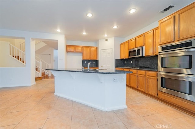 kitchen featuring recessed lighting, visible vents, decorative backsplash, appliances with stainless steel finishes, and dark stone countertops