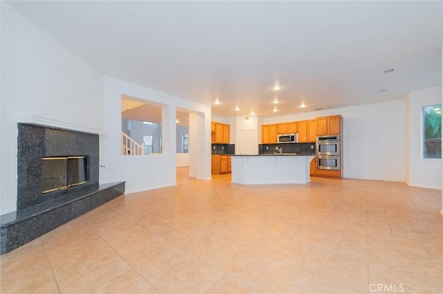 unfurnished living room with recessed lighting, light tile patterned floors, and a premium fireplace