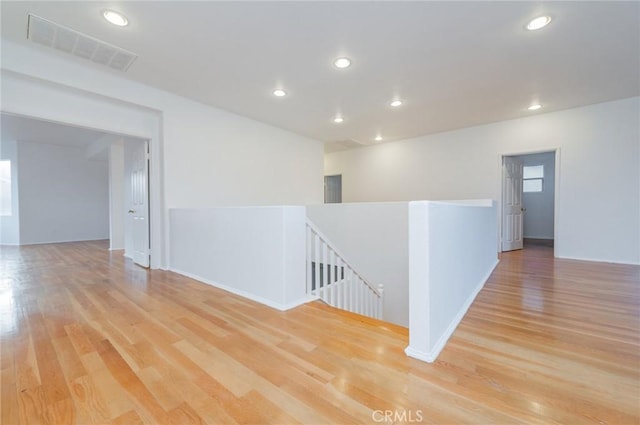 unfurnished room with light wood-type flooring, visible vents, and recessed lighting