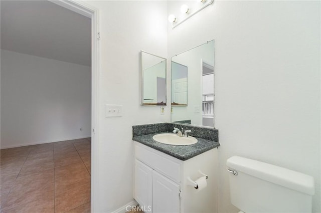 bathroom featuring toilet, tile patterned flooring, and vanity