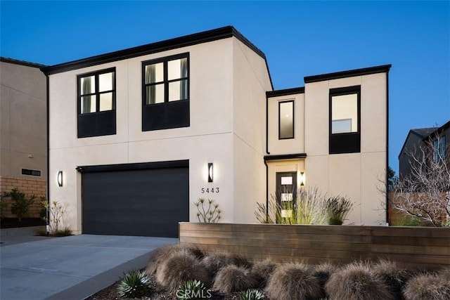 view of front of property featuring a garage, driveway, and stucco siding