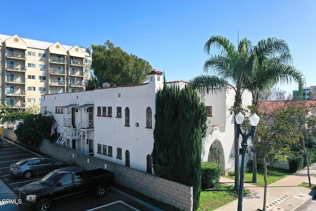 view of property featuring uncovered parking and fence