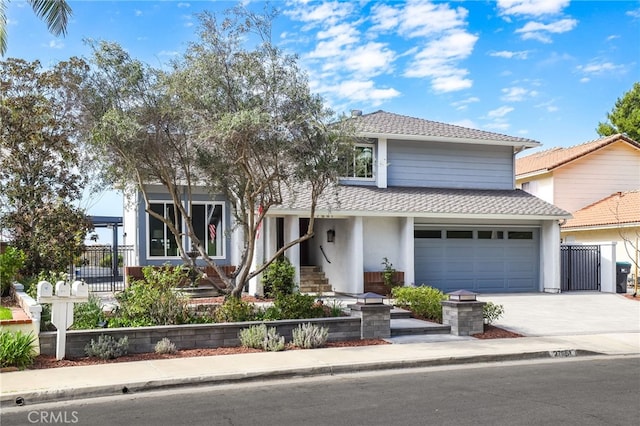 view of front of house with a garage, driveway, a shingled roof, fence, and stucco siding