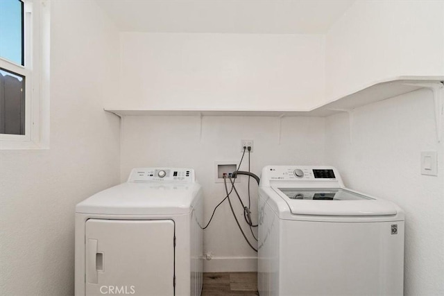 clothes washing area featuring laundry area, wood finished floors, and independent washer and dryer