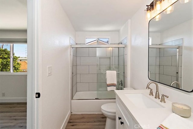 bathroom featuring vanity, plenty of natural light, wood finished floors, and toilet