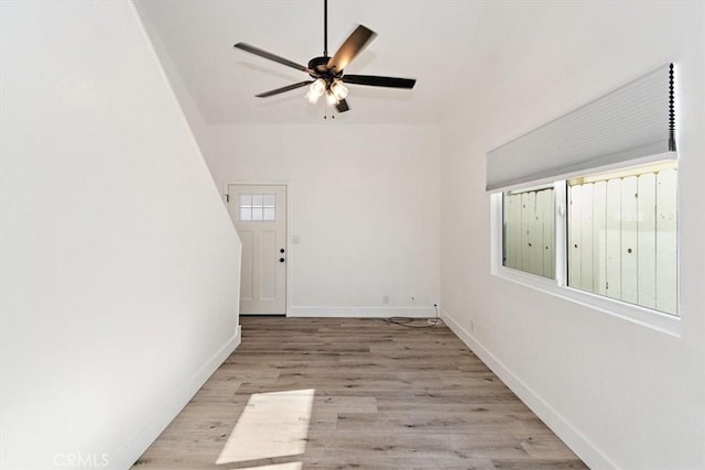 empty room with a ceiling fan, baseboards, and wood finished floors