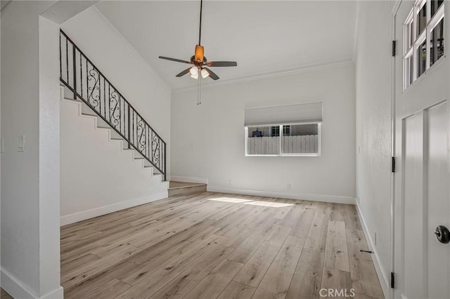 unfurnished living room featuring wood-type flooring, ornamental molding, and baseboards