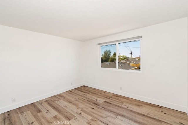 empty room featuring baseboards and wood finished floors