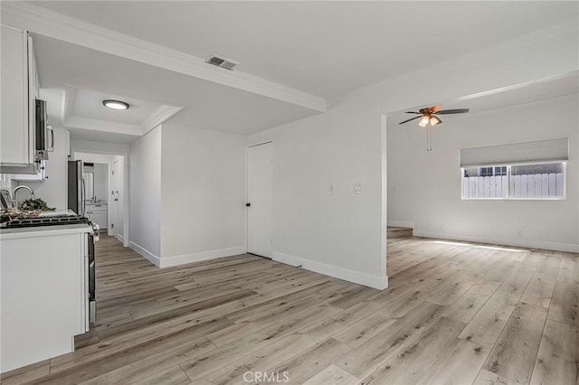 unfurnished room with baseboards, visible vents, crown molding, and light wood finished floors