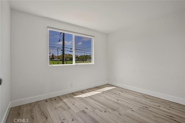 unfurnished room with baseboards and wood finished floors