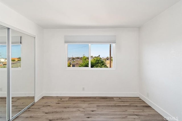 empty room featuring light wood-style floors and baseboards