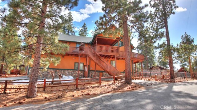 rustic home with stairs, a deck, and fence