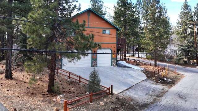 chalet / cabin with concrete driveway and an attached garage