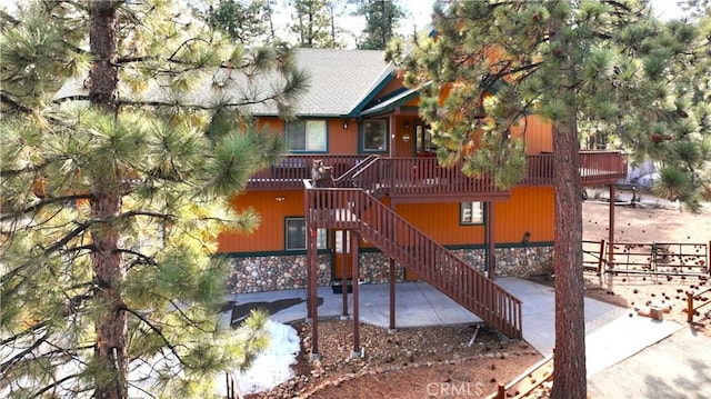 exterior space featuring stairway and stone siding