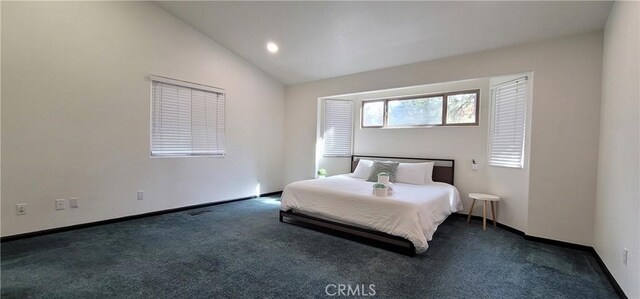 bedroom with dark colored carpet, baseboards, and vaulted ceiling