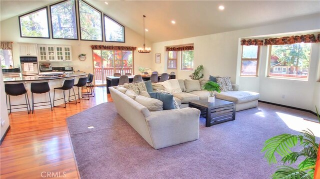 living room featuring a notable chandelier, recessed lighting, high vaulted ceiling, and light wood-style floors