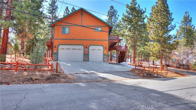 view of front of property with concrete driveway, stairs, and a garage