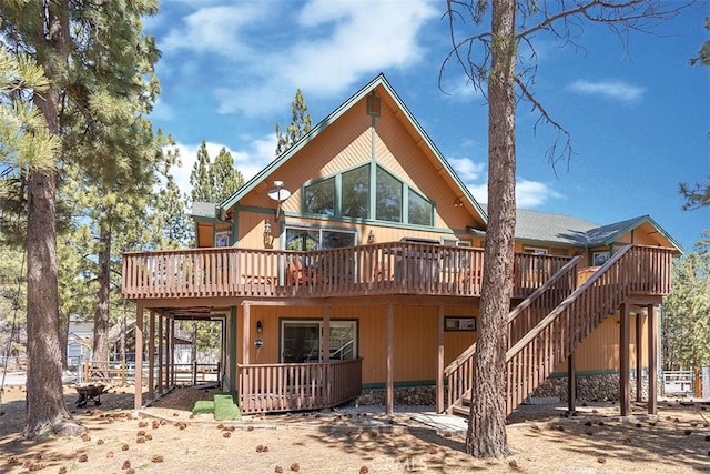 rear view of house featuring a deck and stairway