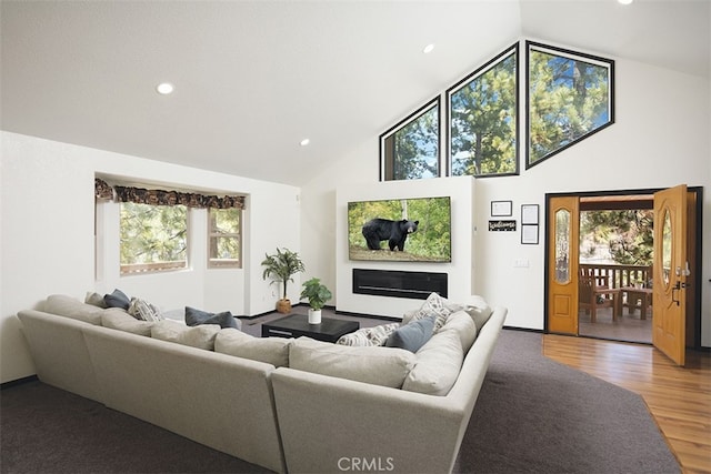 living room with high vaulted ceiling, recessed lighting, and wood finished floors
