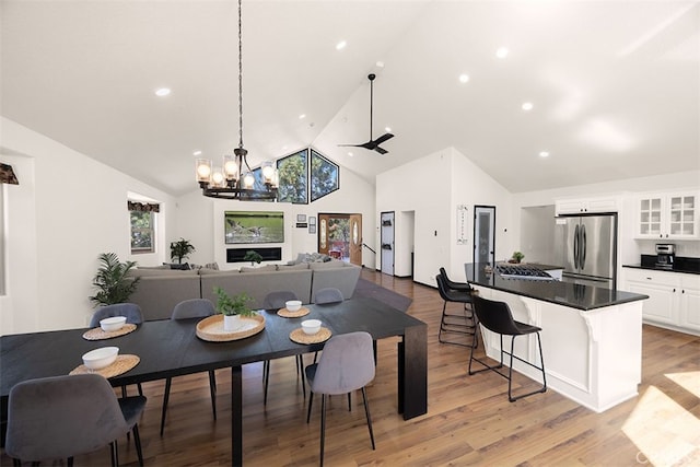 dining room with high vaulted ceiling, a chandelier, light wood-type flooring, and recessed lighting