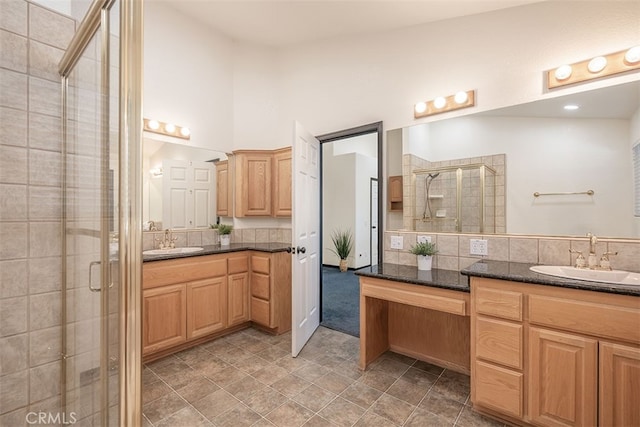 full bath featuring a stall shower, two vanities, and tasteful backsplash