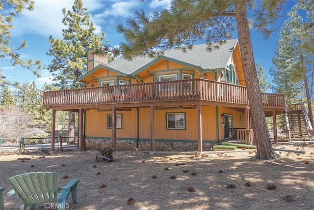 back of property featuring a deck, stairway, and fence