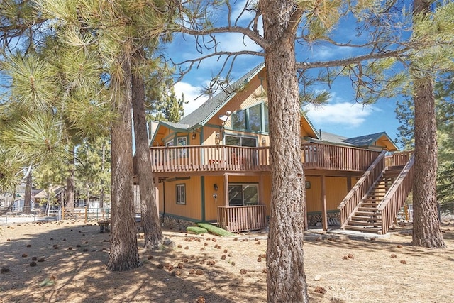 back of property featuring a wooden deck and stairway