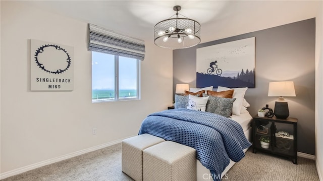 carpeted bedroom featuring baseboards and an inviting chandelier