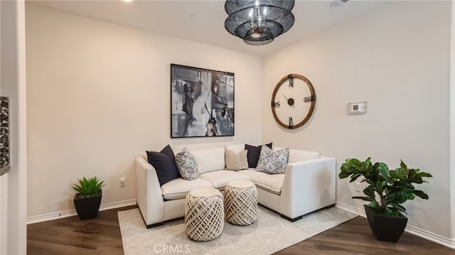 living room with wood finished floors, visible vents, and baseboards