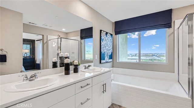 ensuite bathroom with a shower stall, a sink, visible vents, and a healthy amount of sunlight