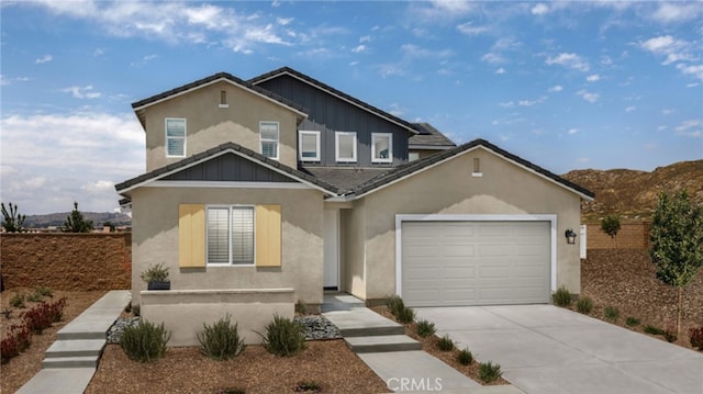 traditional-style house with an attached garage, fence, concrete driveway, and stucco siding